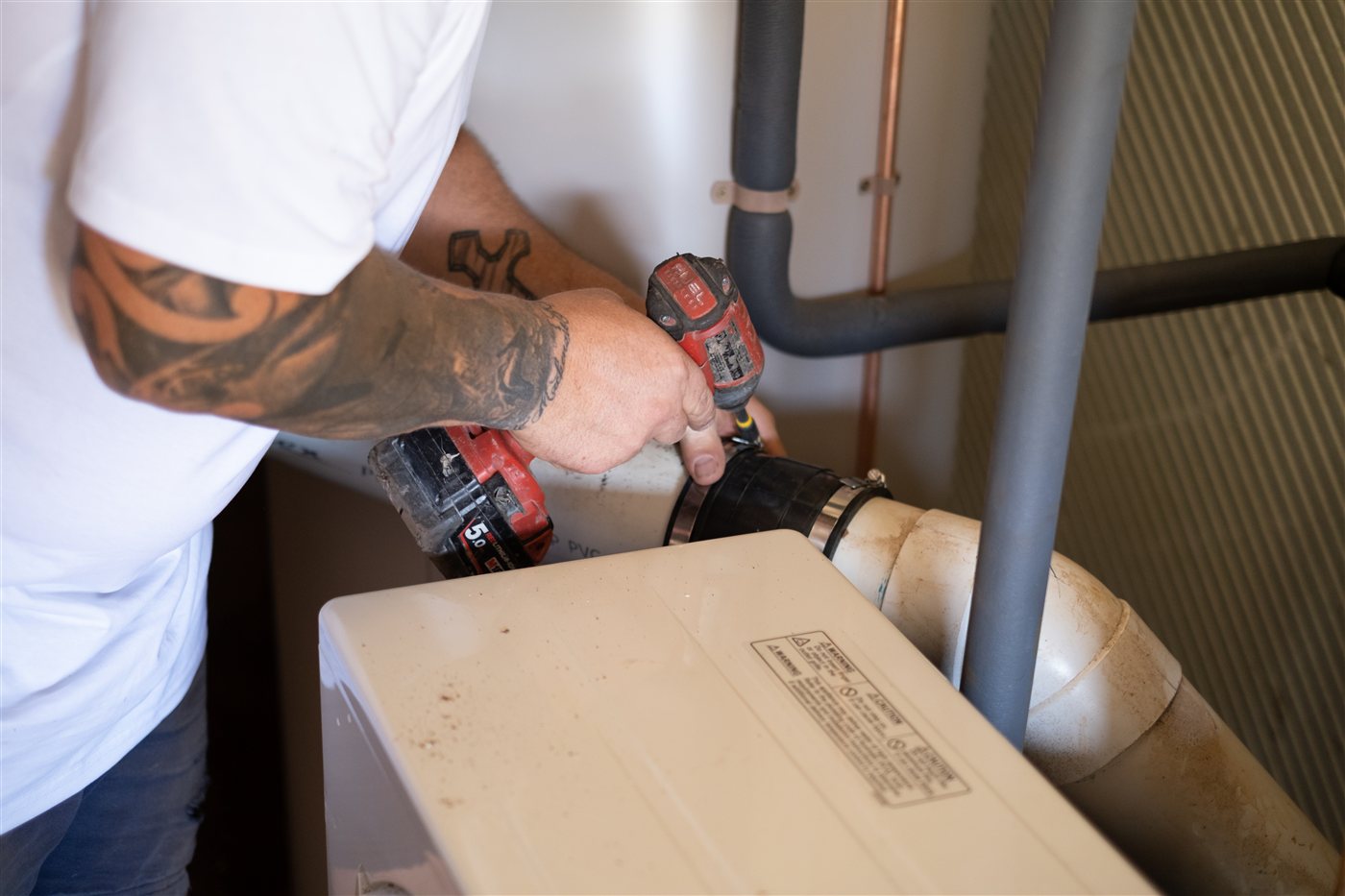 Peninsula Heat Pumps installer plumbing in a heat pump